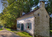 Lockhouse 22 is a home directly on the towpath and is a whitewash brick home with a large tree on one side