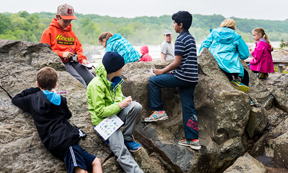 Children explore rocks near Great Falls in Canal Classrooms program.