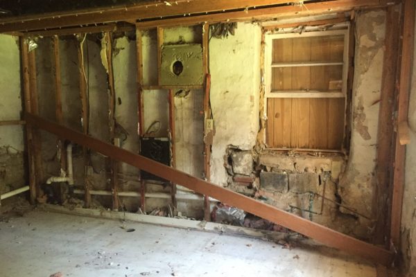 Post-demo: Downstream wall in kitchen, with water-damaged window base to right.