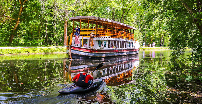 A kayaker passes the Mercer canal boat.
