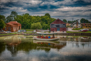 Photo by Mark Crilley. Visitors go for a NPS led boat ride in the Cushwa Basin. The Cushwa brick building and trolley barn is seen in the background.