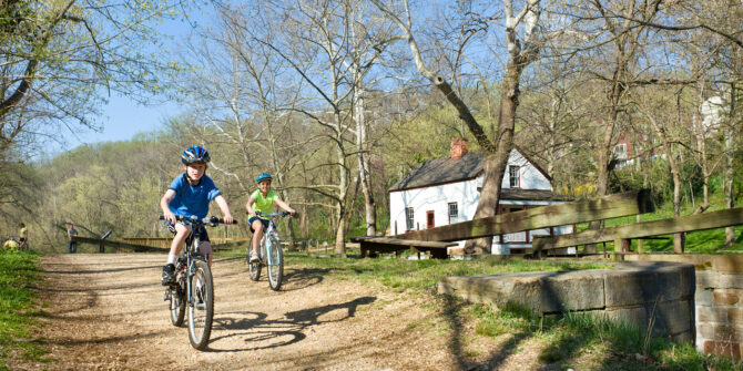 Two children ride their bikes on the towpath